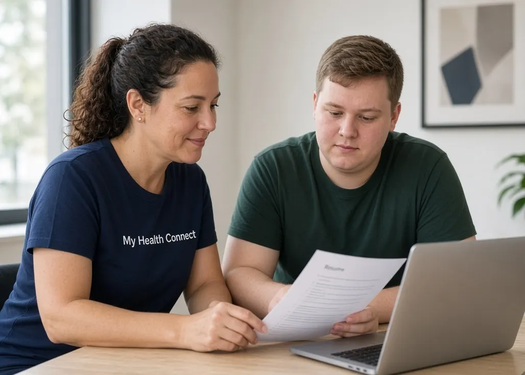 A My Health Connect support worker and a participant reviewing a resume together at a laptop.